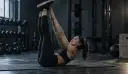 Toe touch med strakte ben løftet lodret og hænderne rakt op mod tæerne